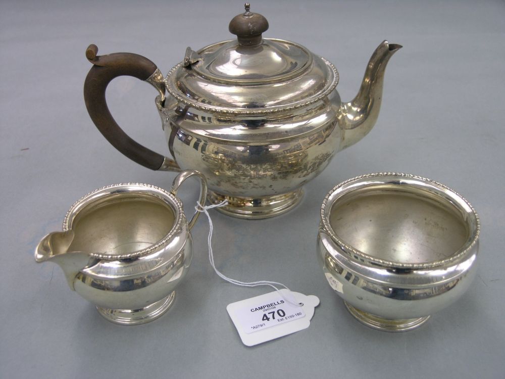 Appraisal: A silver teaset teapot with wood handle sugar bowl and