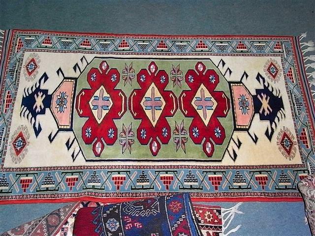 Appraisal: A TURKISH POLYCHROME RUG with three central medallions and geometric