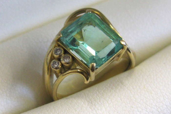 Appraisal: EMERALD DIAMOND AND EIGHTEEN KARAT GOLD RING set with three