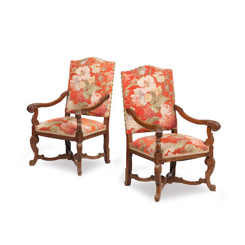 Appraisal: A pair of Edwardian oak framed open armchairs Each padded