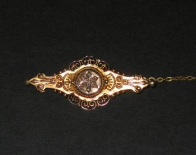 Appraisal: A VICTORIAN BROOCH the centre set with diamond chips in