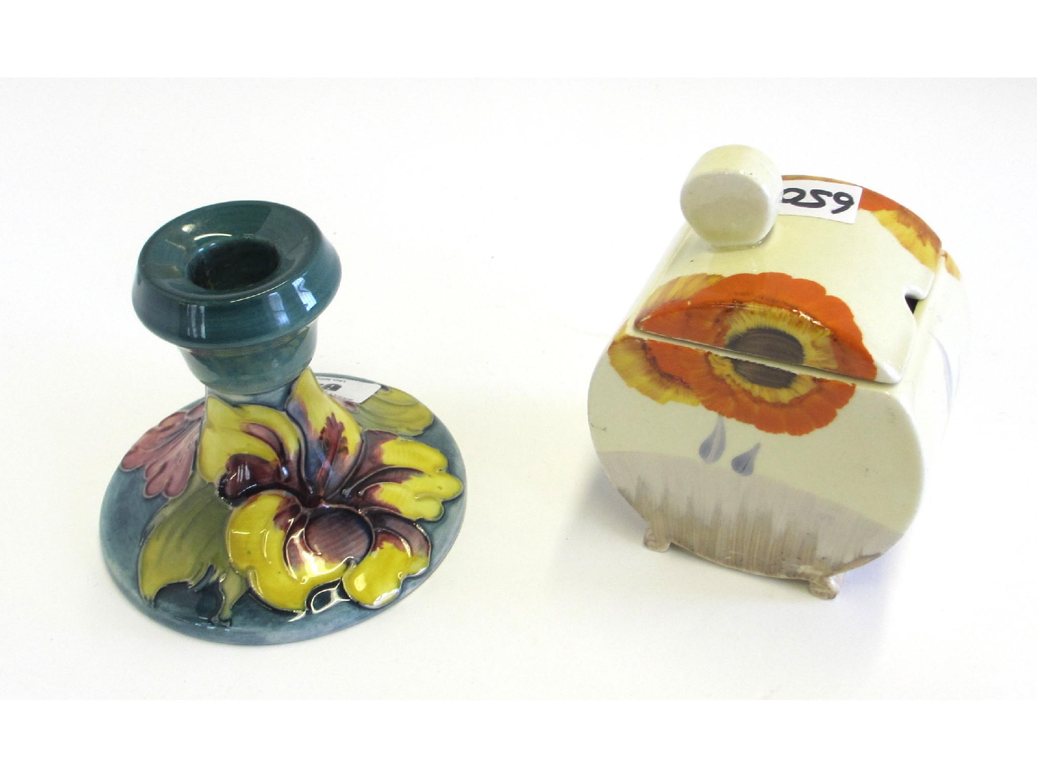 Appraisal: Moorcroft hibiscus green glazed candlestick and a Clarice Cliff Rhodanthe