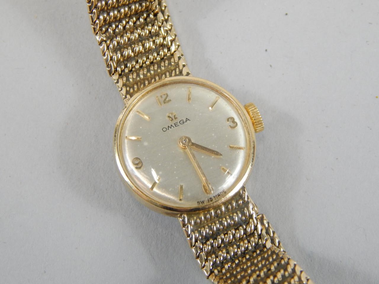 Appraisal: A ct gold ladies Omega wristwatch with solid bark effect