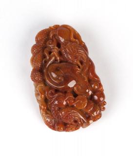 Appraisal: A carved jadeite jade toggle on cord An orangey-brown jadeite