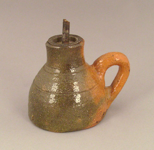 Appraisal: Redware oil lamp ca with green and orange glaze h