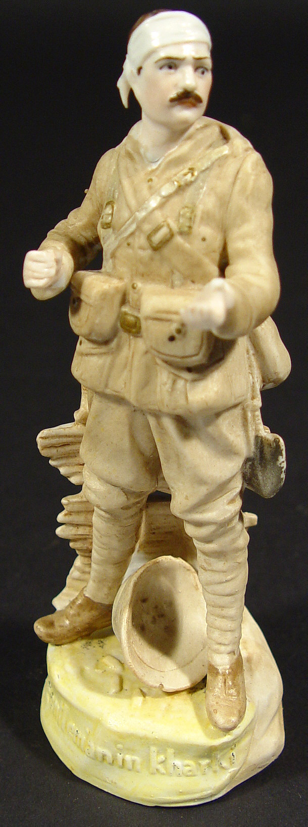 Appraisal: Military interest bisque figure of a wounded soldier with script