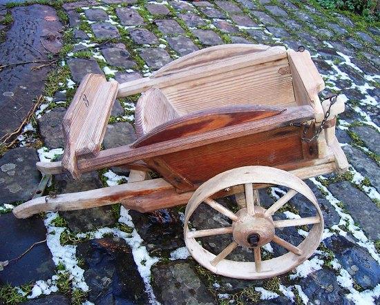 Appraisal: A child's pine cart with wooden wheels cm long stamped