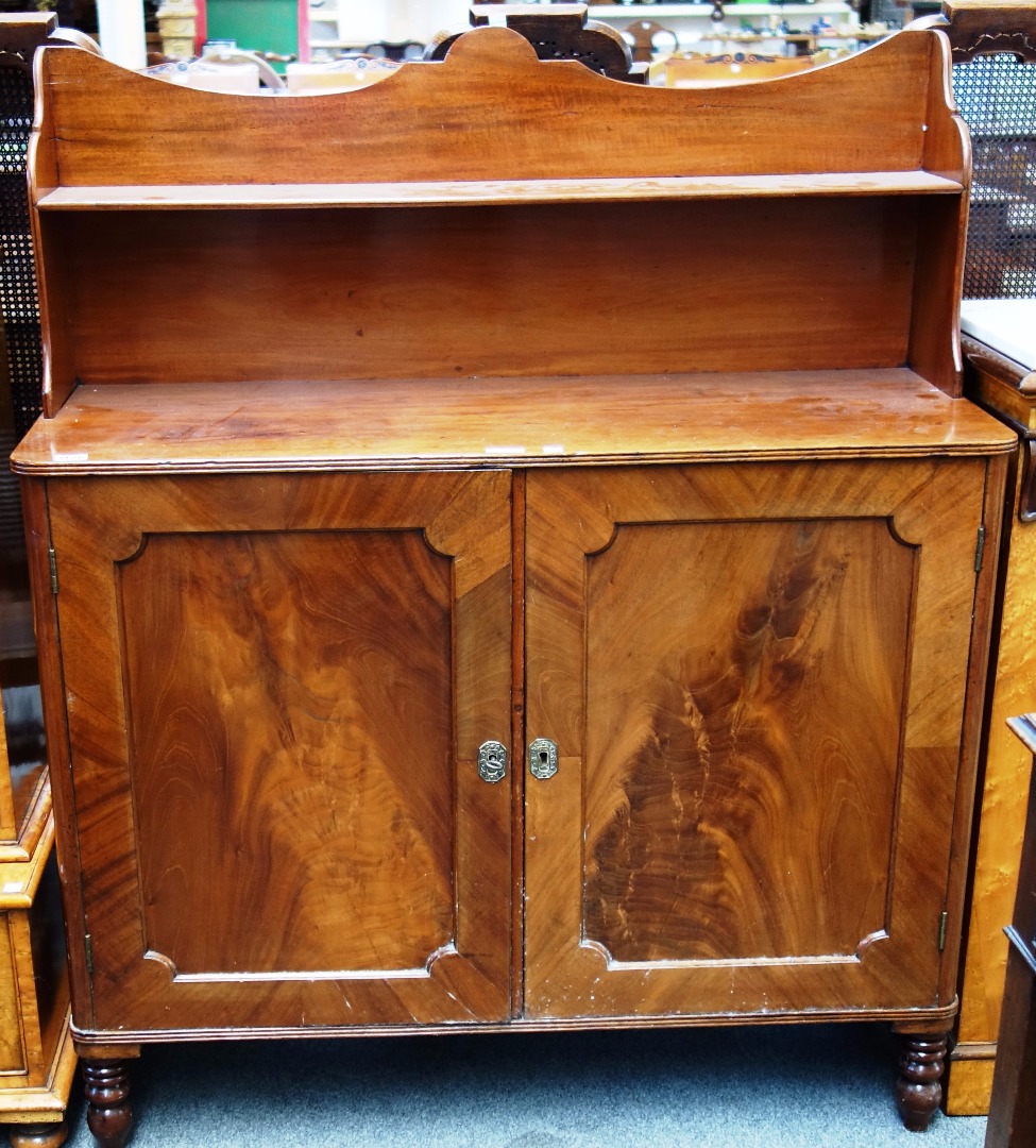 Appraisal: An early th century mahogany chiffonier with concave shelf back