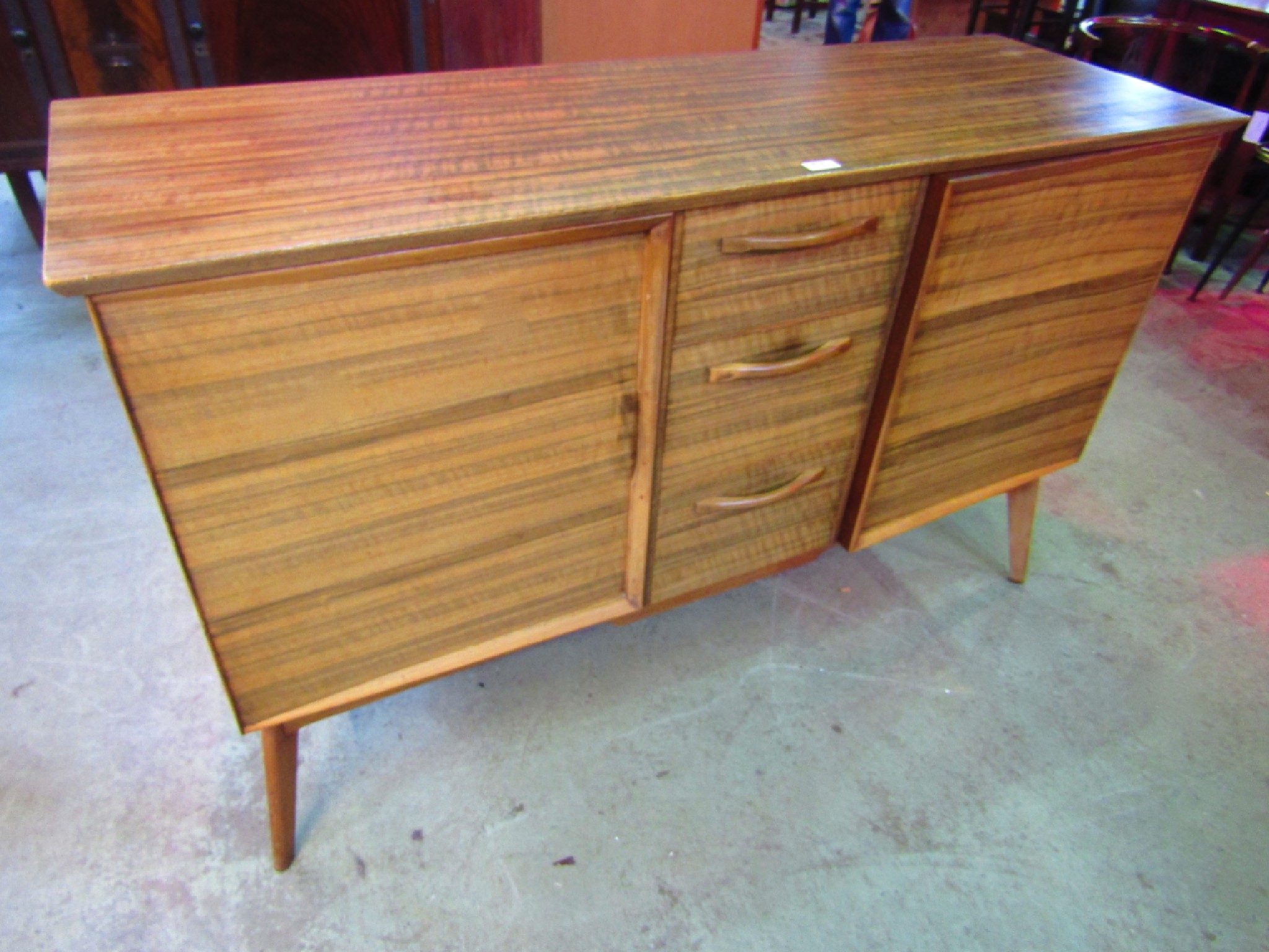 Appraisal: A mid th century Alfred Cox walnut veneered sideboard partially