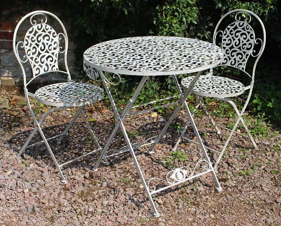 Appraisal: A CREAM PAINTED FOLDING CIRCULAR CAFE TABLE the pierced top