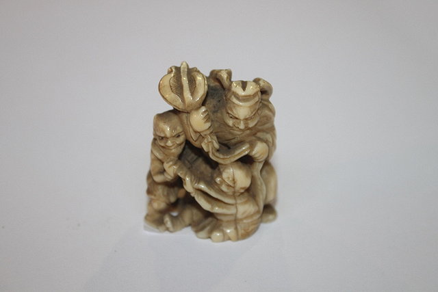 Appraisal: A JAPANESE IVORY NETSUKE of Shoki acting as a referee