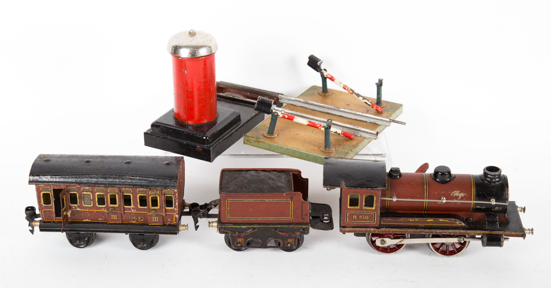 Appraisal: tin wind-up engine tender passenger car with a crossing gate