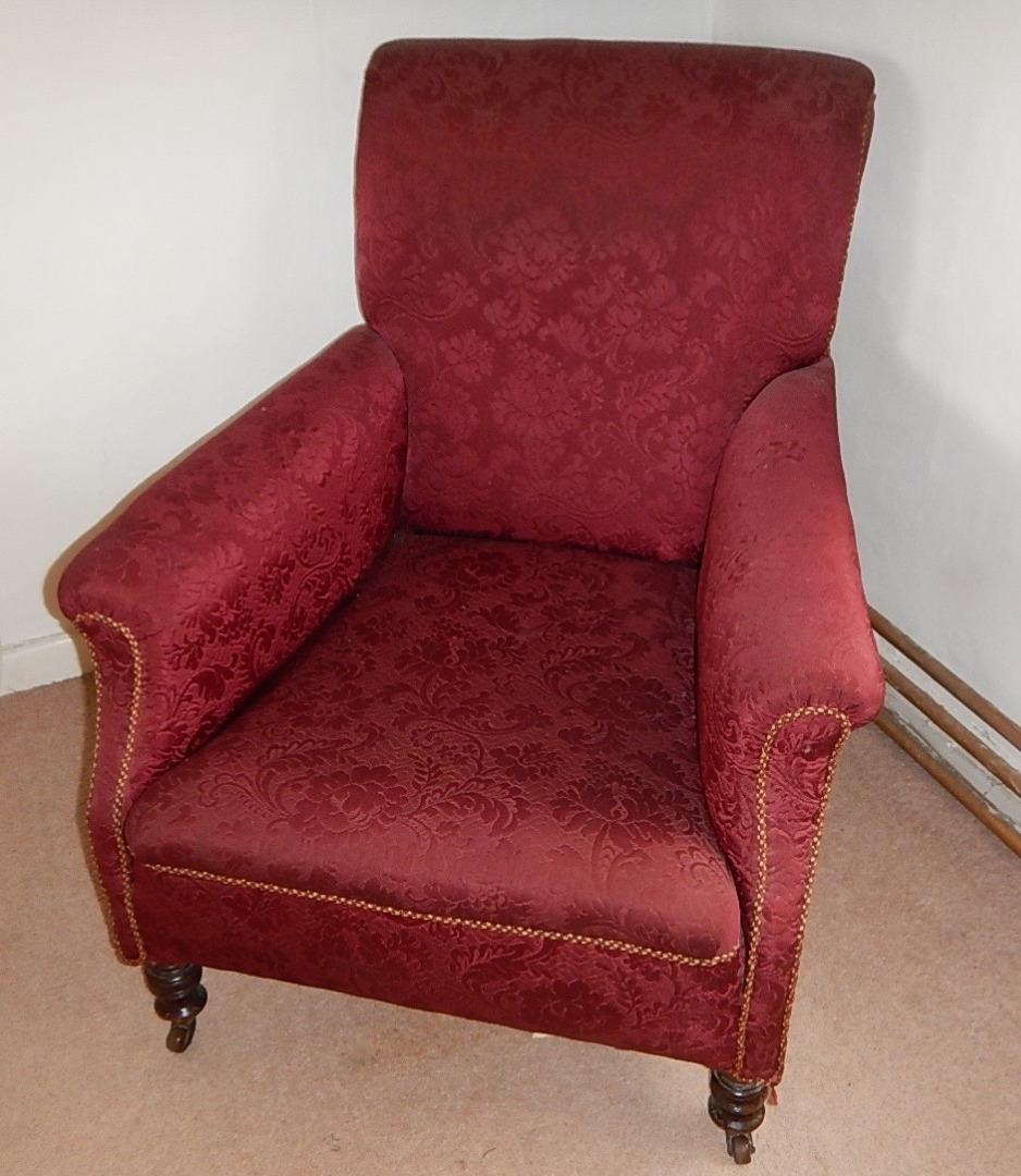 Appraisal: A late Victorian upholstered armchair in maroon pattern upholstery on