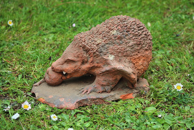 Appraisal: A SMALL TERRACOTTA SCULPTURE OF A HEDGEHOG EATING A CRABAPPLE