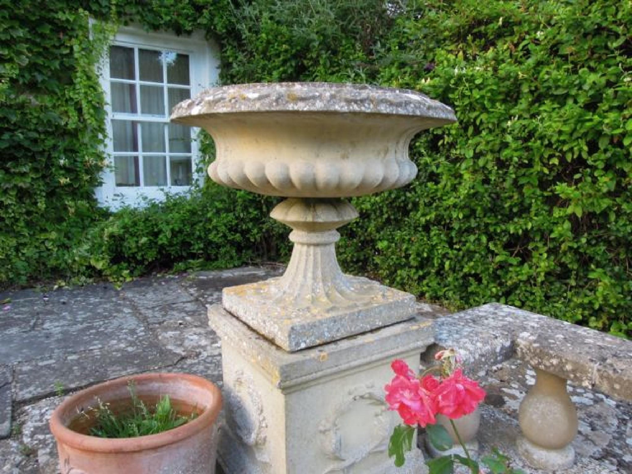 Appraisal: A pair of reconstituted weathered urns of classical form on