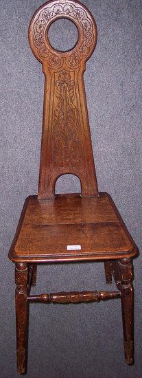 Appraisal: A Welsh oak spinning wheel chair with carved panel back