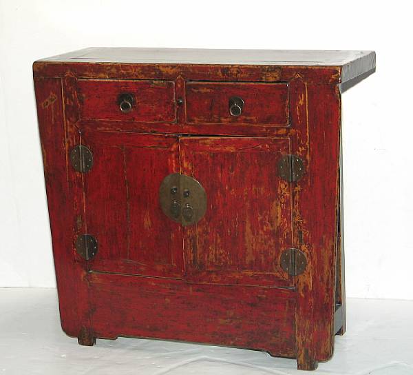 Appraisal: A red and black lacquered soft wood cabinet Fitted with