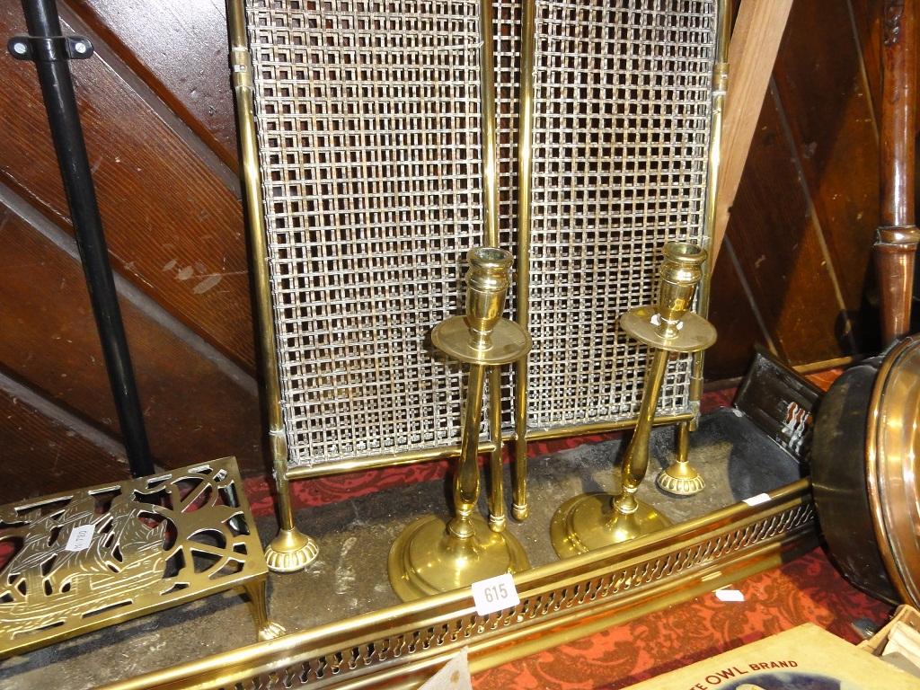 Appraisal: A pair of slender brass candlesticks a fire fender brass