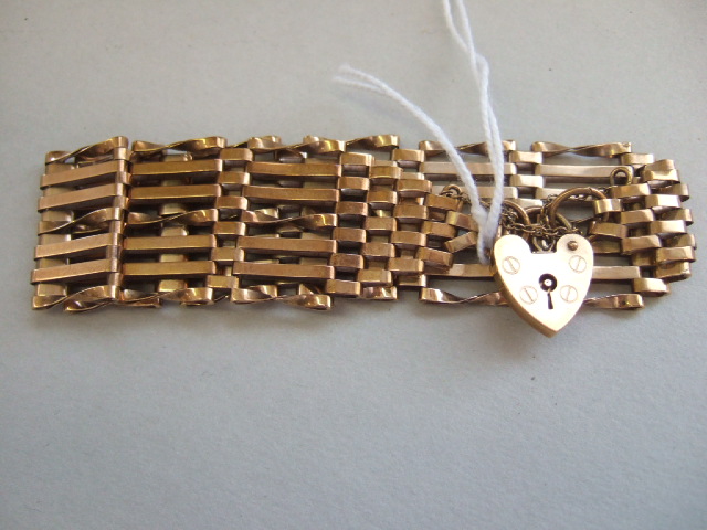 Appraisal: A gold bar twisted bar and oval link gate bracelet