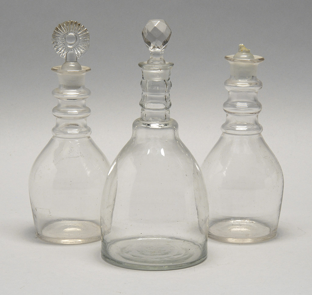 Appraisal: THREE BLOWN-MOLDED CLEAR GLASS DECANTERS th CenturyWith stoppers Heights approx