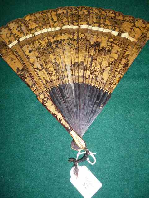 Appraisal: AN OLD ORIENTAL BLACK AND GOLD LACQUERED FAN the sticks