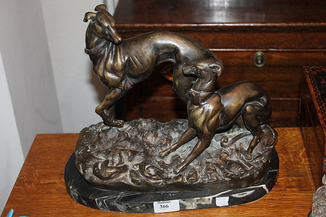 Appraisal: A CAST BRONZE FIGURE GROUP showing two greyhounds playing on