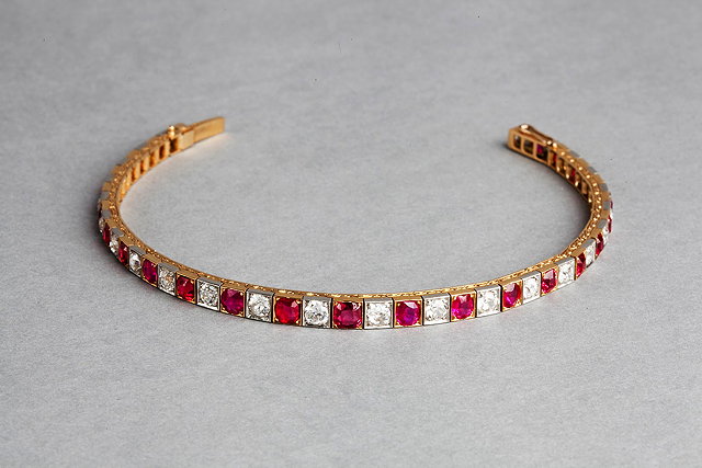 Appraisal: A GRADUATED RUBY AND DIAMOND SET PANEL BRACELET hinged square