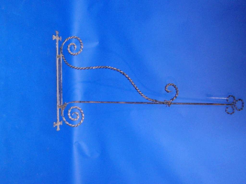 Appraisal: A wrought iron sign bracket with spiral trefoil terminal and