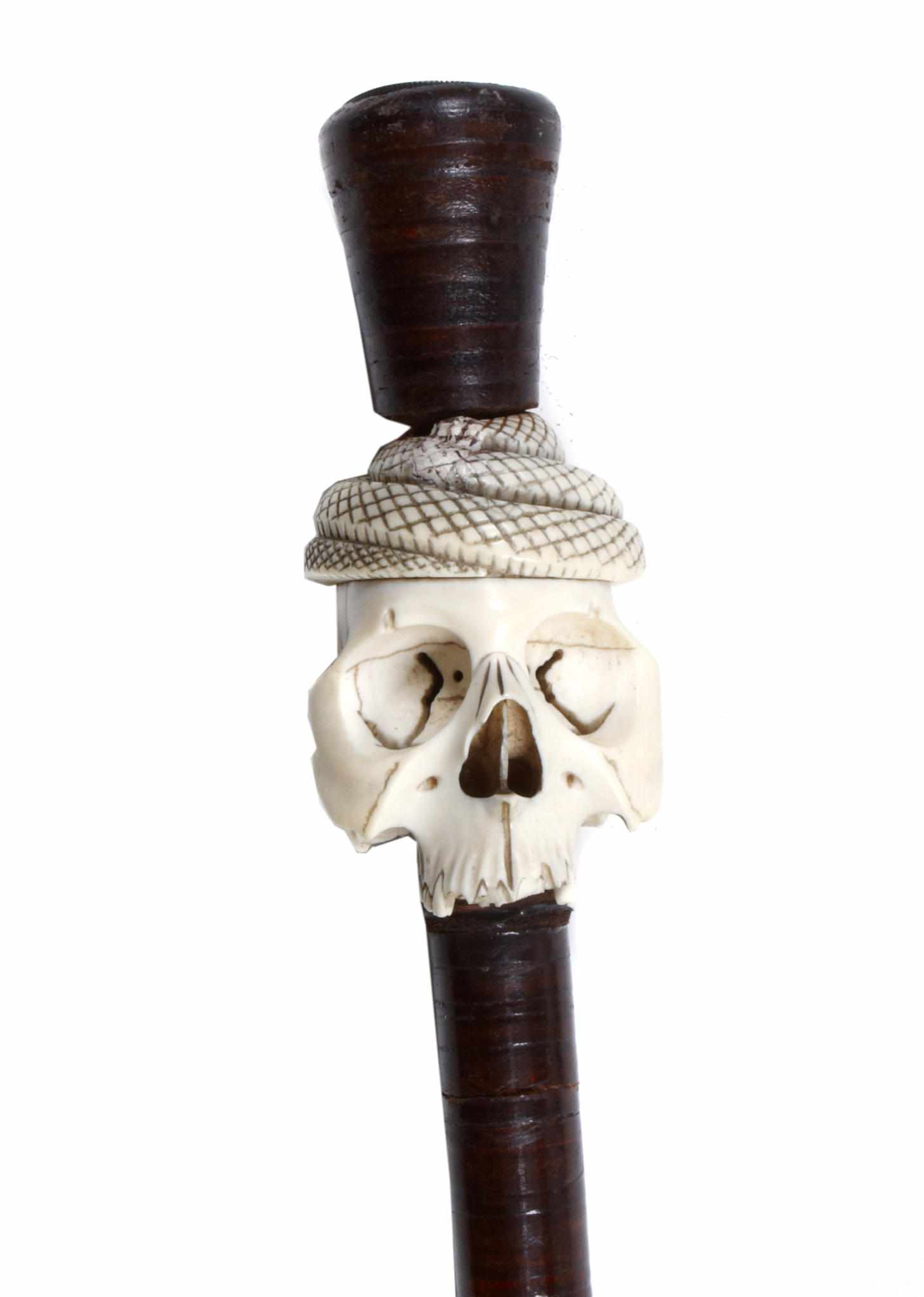 Appraisal: A walking stick with carved ivory skull and serpent knop