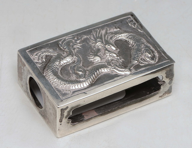 Appraisal: A CHINESE WHITE METAL MATCHBOX HOLDER with wrythen dragon decoration