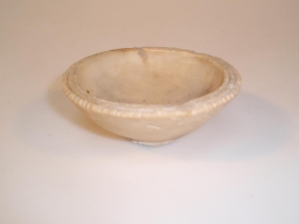 Appraisal: An ancient shallow alabaster bowl with a flat horizontal rim