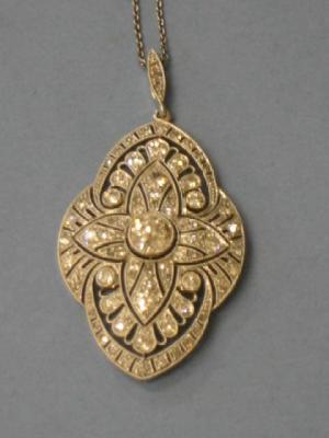 Appraisal: AN EDWARDIAN DIAMOND PENDANT of shaped oval form having central