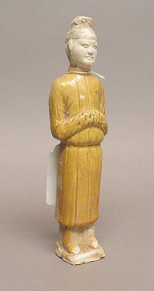 Appraisal: A Tang style yellow glazed mortuary attendant The standing figuredressed