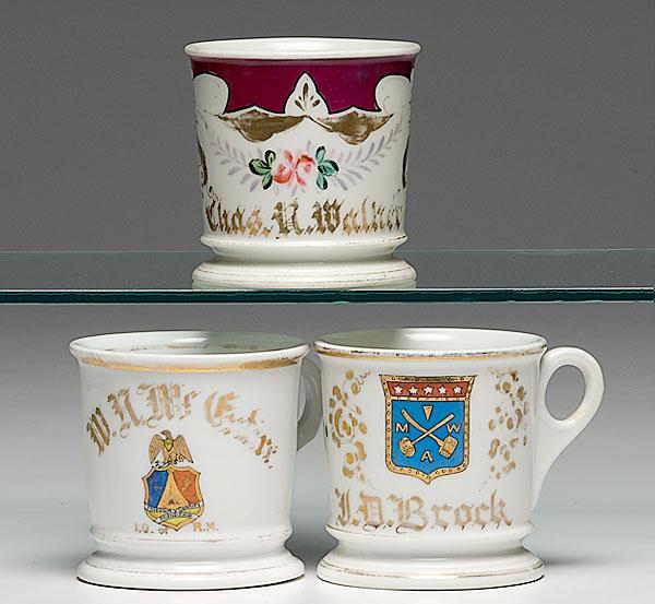 Appraisal: THREE FRATERNAL SHAVING MUGS porcelain with polychrome painted scenes including