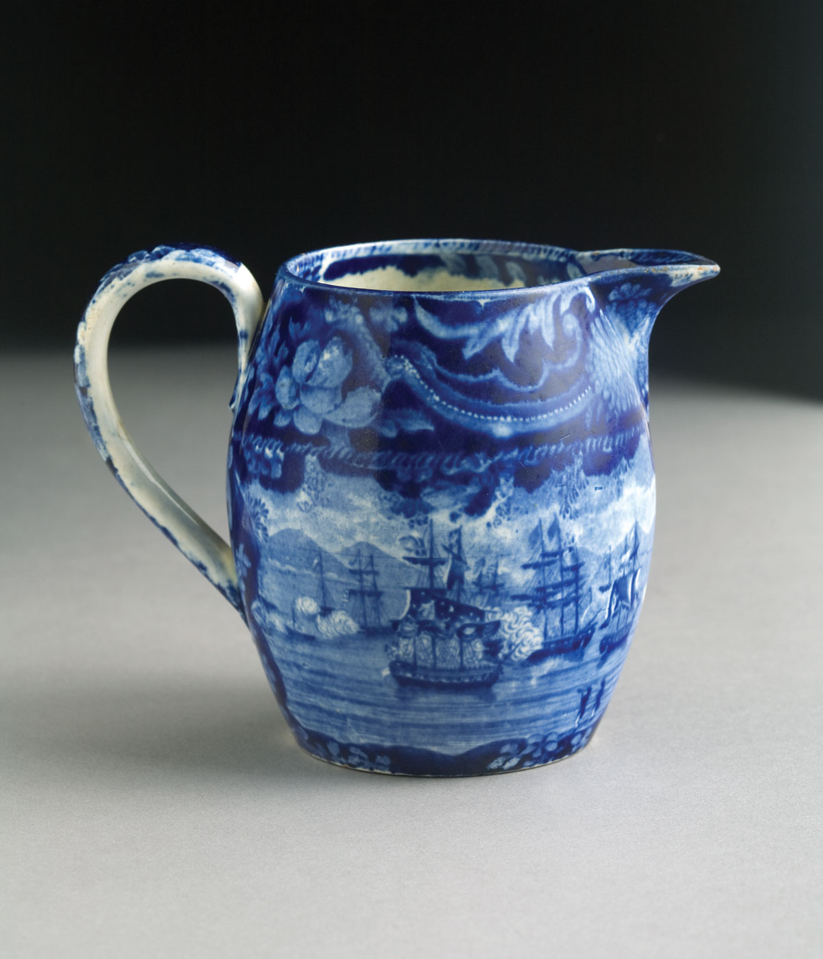 Appraisal: COMMODORE MACDONNOUGH'S VICTORY SHELL BORDER-IRREGULAR CENTER DARK-BLUE STAFFORDSHIRE CREAM JUG