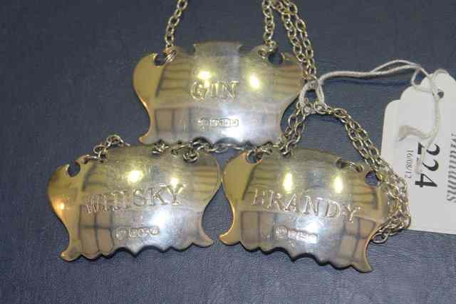 Appraisal: THREE SILVER SPIRIT LABELS Gin Whisky and Brandy each with