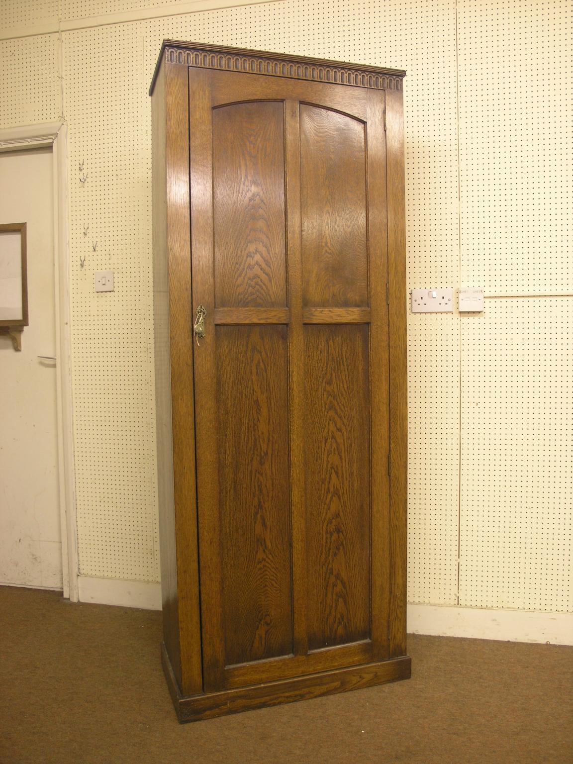 Appraisal: A solid dark oak hall cupboard enclosed by single full-length