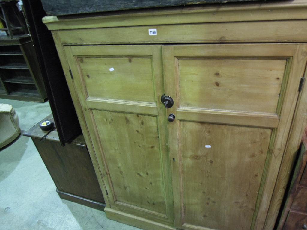 Appraisal: A stripped pine side cupboard enclosed by a pair of