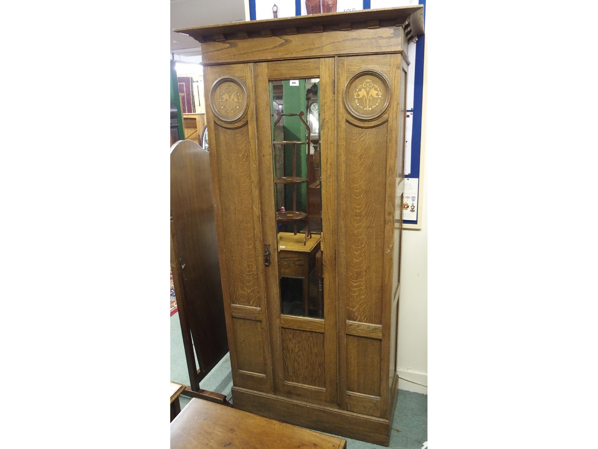 Appraisal: An oak Arts and Crafts single door mirrored inlaid wardrobe