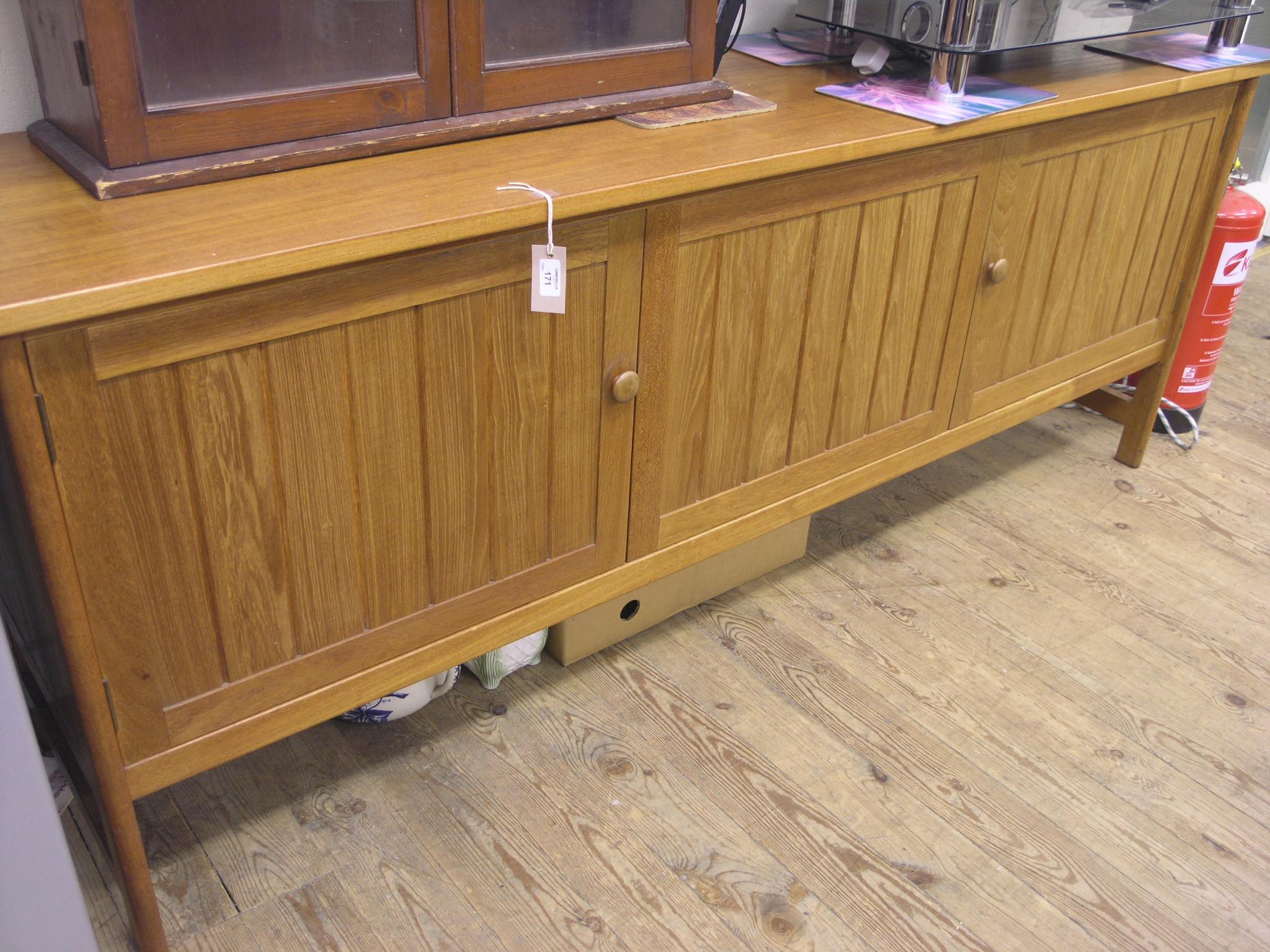 Appraisal: A large Younger teak sideboard four drawers and two cupboards