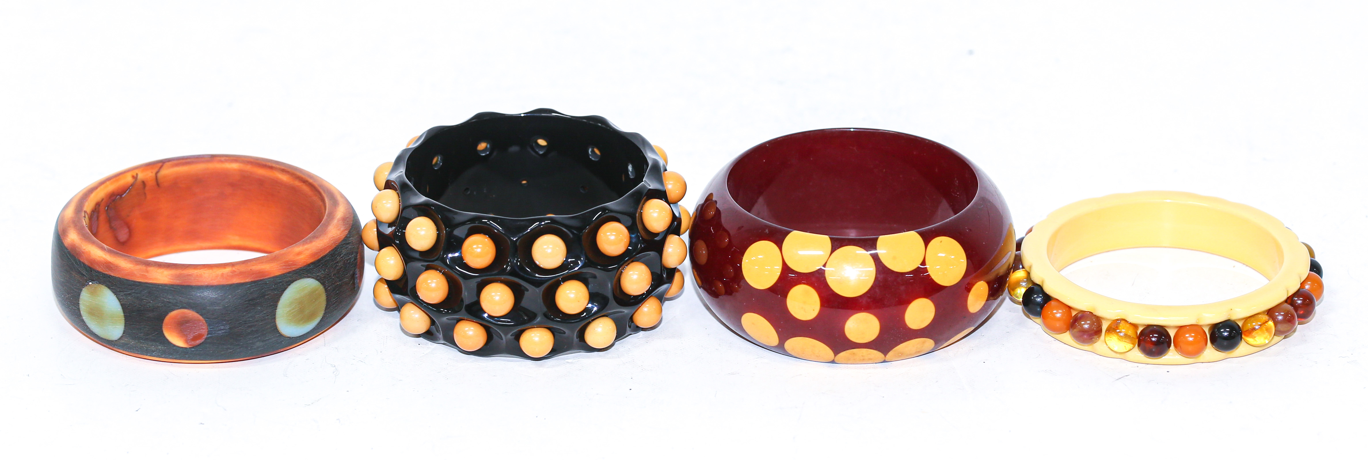 Appraisal: FOUR POLKA DOT BAKELITE BANGLES Including black and yellow polka