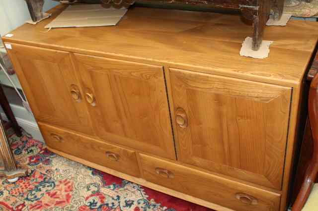 Appraisal: A TH CENTURY ERCOL SIDEBOARD with three cupboard doors above