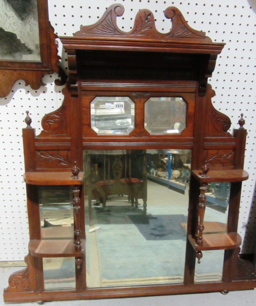 Appraisal: An Edwardian walnut overmantel mirror with integral shelves