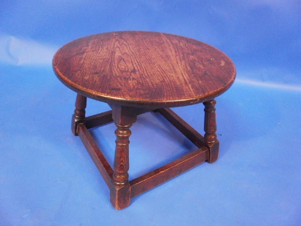 Appraisal: A small elm topped occasional table the circular top above