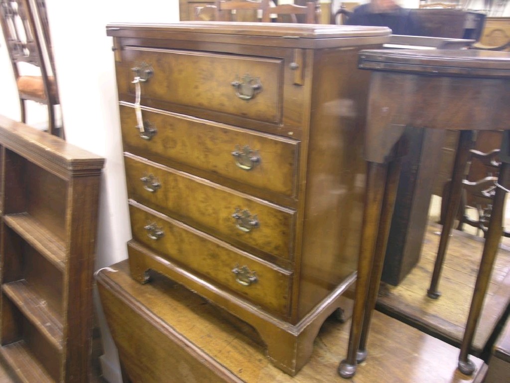 Appraisal: A reproduction burr walnut bachelor's chest folding top supported upon