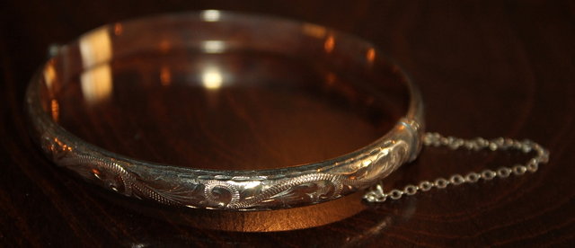 Appraisal: A CT GOLD BANGLE with engraved decoration grams