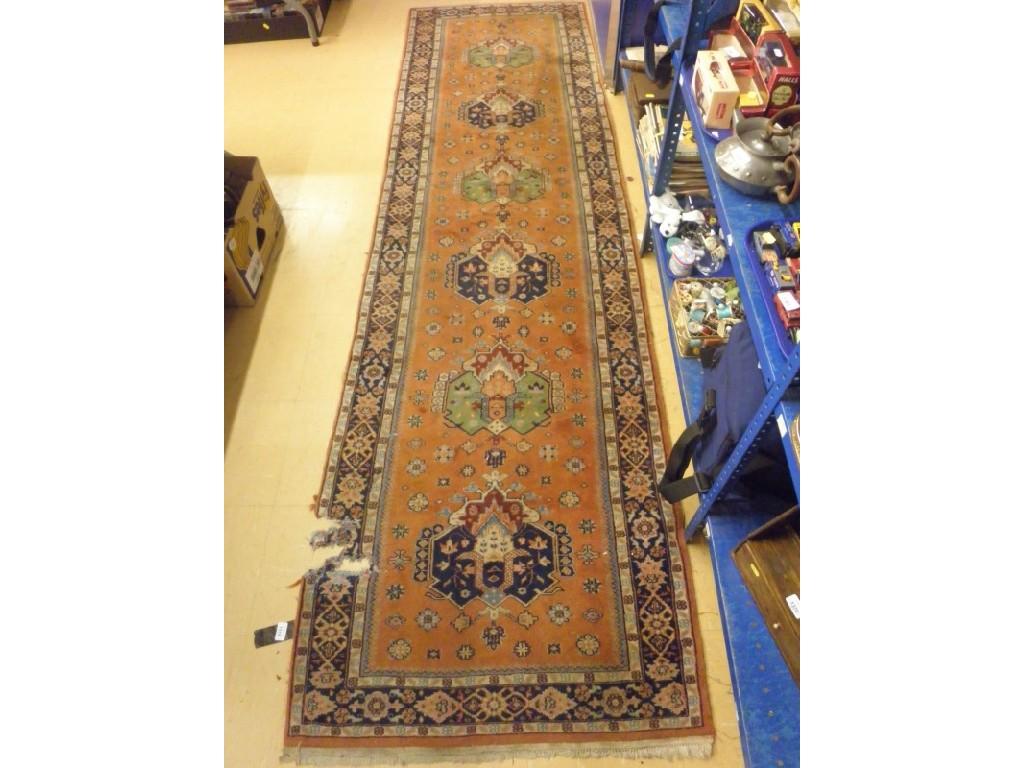 Appraisal: A Persian style runner with six medallions on an orange