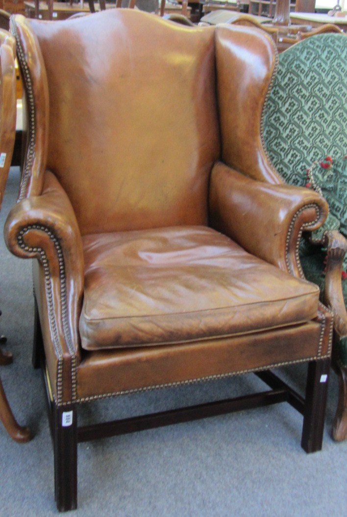 Appraisal: An th century style leather upholstered wingback armchair on block