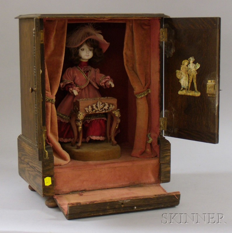 Appraisal: Cecile' Music Automata Doll the two-door ball-footed oak cabinet with