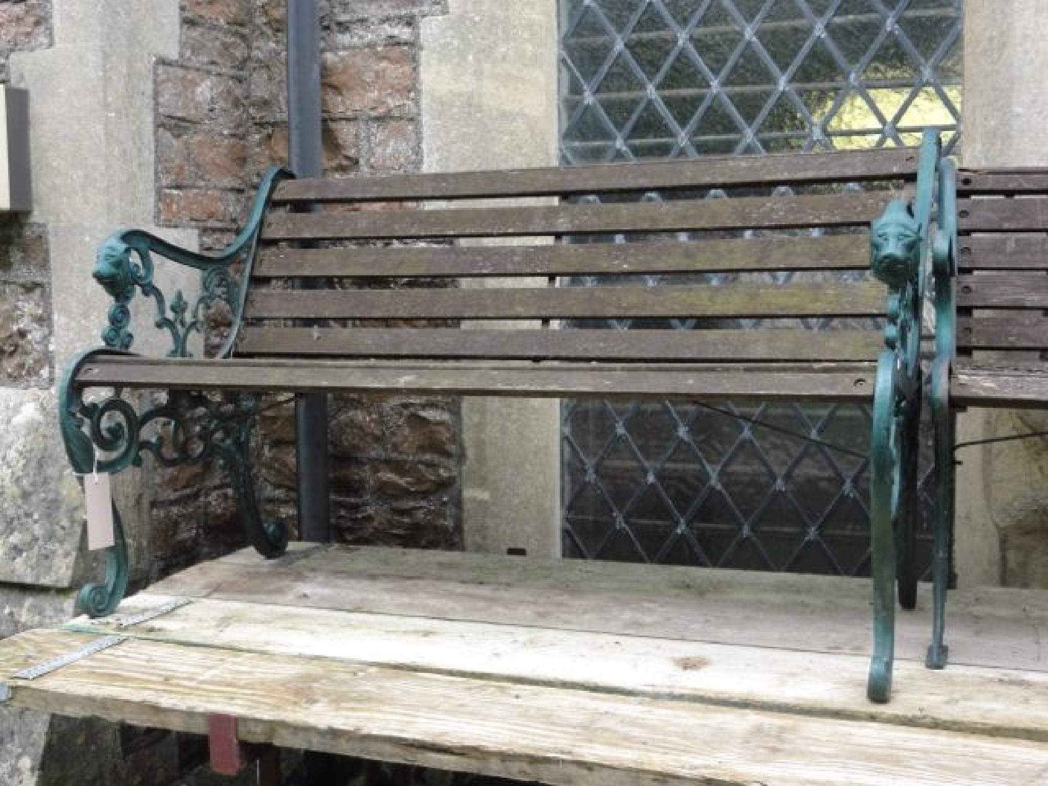 Appraisal: A two seat garden bench with weathered timber slatted seat